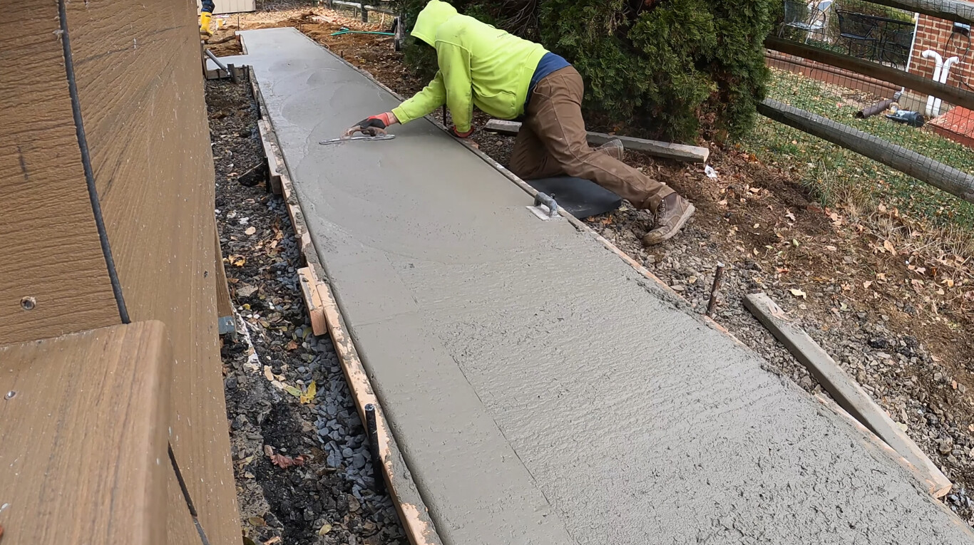Worker finishing a smooth concrete walkway in Fond du Lac, WI